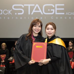 backstage academy 导师颁发毕业证书给毕业生，学生毕业即有充足的实际彩妆经验